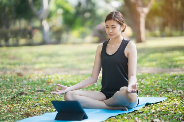 在公园的户外视频会议上学习瑜伽的年轻女性 运动瑜伽的概念 — 图库照片