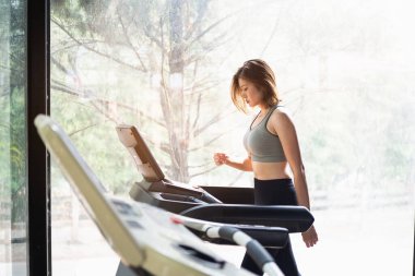 Güzel kadınlar spor salonunda koşu bandıyla egzersiz yapıyorlar, spor konsepti.