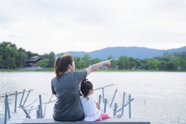 Anne ve kızı oturmuş nehire bakıyorlar.