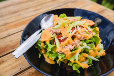 Tahta masadaki ton balıklı taze sebze salatası.