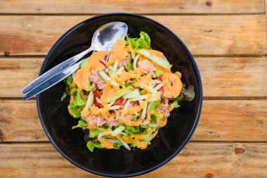 Tahta masadaki ton balıklı taze sebze salatası.