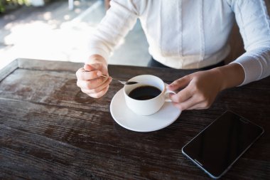 Eller kadın kahve ve moblie ahşap masa üzerinde kapat