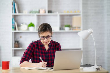 Dizüstü bilgisayarda çalışan güzel bir kız, ev konsepti olarak çalışıyor.