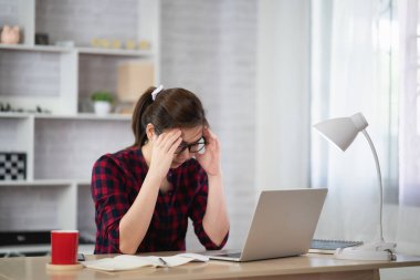 Çalışan kadınlar dizüstü bilgisayarla ciddi şekilde evde çalışıyorlar, ev konseptinden çalışıyorlar.