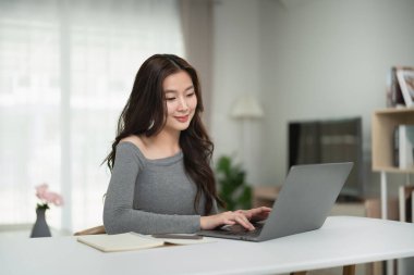 Konforlu Oturma Odasında Dizüstü bilgisayarla Evden Çalışan Genç Kadın Yumuşak Aydınlatma ve Konforlu Ambiyansla