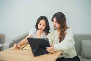 Modern İçişlerinde Fikir ve İlham İçin Evde Tablet, Not Defteri ve Kalemle Yaratıcı Beyin Fırtınası Yapan İki Genç Kadın