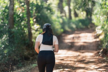 Tozlu Bir Yolda Koşan Kadın Doğal Çevrede Yeşillik, Sağlıklı Yaşam İçin Spor ve Açık Hava Faaliyetlerini Destekliyor