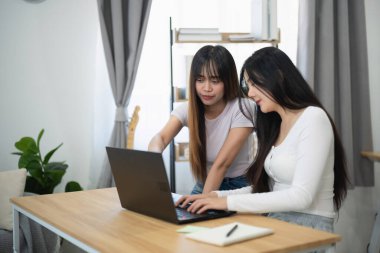 Parlak İçişleri Ofisi 'nde Dizüstü bilgisayarda İşbirliği Yapan İki Genç Kadın Pencerelerden Bitkiler ve Doğal Işık Akımı Yapıyor