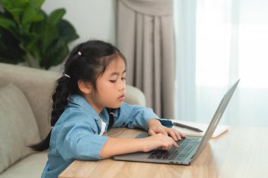 Modern Oturma Odasında Dizüstü bilgisayarda Çalışan, Doğal Işıkla Öğrenme veya Ödev Etkinliği Yapan Odaklanmış Genç Kız