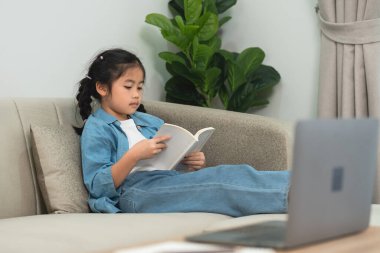 Koltukta Rahatlayan Genç Kız, Evde Kitap Okuma, Laptoplu Kapalı Sahne, Konforlu Atmosfer, Yeşil Santral, Günlük Kıyafetler, Aydınlık Ayarlar