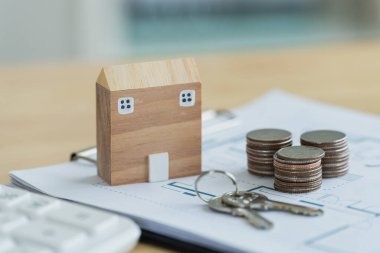 Gayrimenkul yatırımı, tasarruf ve mülkiyet mülkiyet kavramlarını temsil eden anahtar ve sikkelerle finansal belgelere dayalı model ev