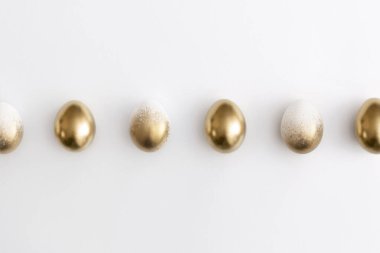 Beyaz arka planda altın yumurtalar. Asgari paskalya kavramı.