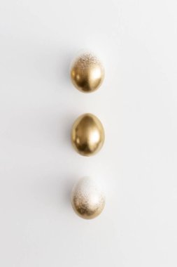 Beyaz arka planda altın yumurtalar. Asgari paskalya kavramı.