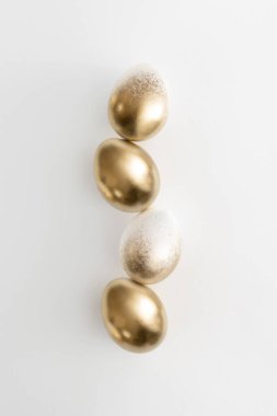 Beyaz arka planda altın yumurtalar. Asgari paskalya kavramı.