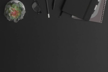 Defteri ve yeşil bitkisi olan siyah deri ofis masası. Kopyalama alanı olan üst görünüm. Düz konum.