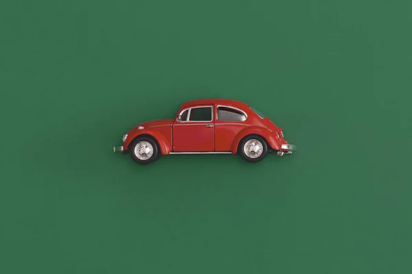 Red toy car on a yellow background. Top view with copy space.
