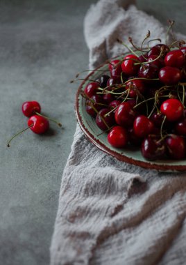 Mutfak beziyle yeşil tabakta taze kiraz.