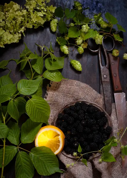 Blackberry em prato de metal com fatia de laranja e folhas verdes, flatlay — Fotografia de Stock