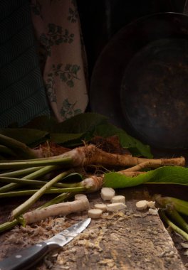 Taze yaban turpu kökleri ahşap masa üzerinde kesilmiş, düşük tuş, seçici odak