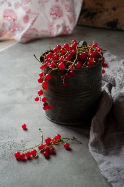 Taze kırmızı üzümlü, metal bir fincanda.