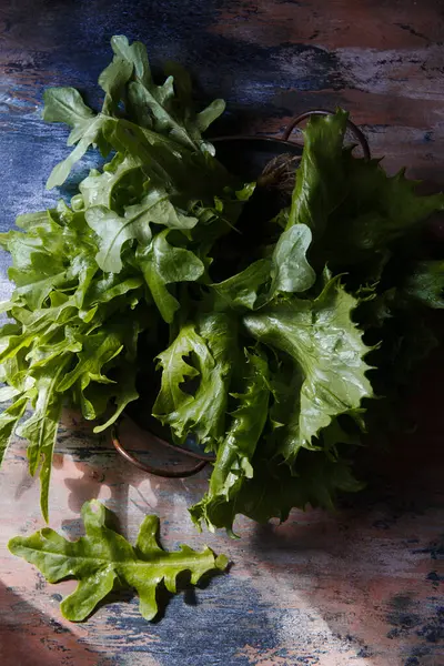 Hojas recién cosechadas de ensalada de lechuga sobre mesa de madera rústica — Foto de Stock