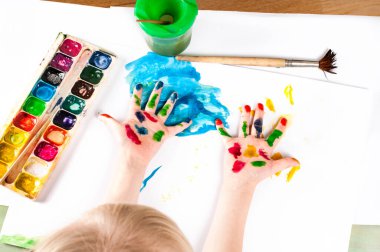 Çocuk kağıda ve avuç içlerine resim çiziyor. Kirli eller. Eğlence. Seçici odak