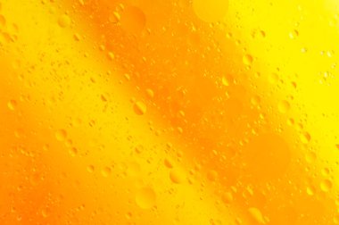 Sarı-turuncu arka planda su ve yağ damlaları. Soyut resim