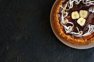 Üstünde elmalar, karamel ve beyaz çikolata olan bir pasta.