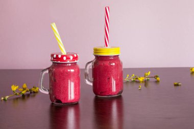 Kapaklı ve pipetli iki kavanoz dut püresi. Boşluğun bir kopyasıyla aydınlatma