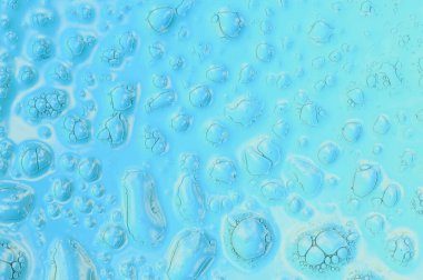 Su mavi arka planda bir yüzeye düşer. Doğal ışık. Arkaplan olarak soyut fotoğrafçılık