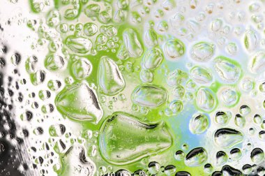 Camdaki yağmur damlaları. Yeşil ve mavi arka plan. Soyut doku