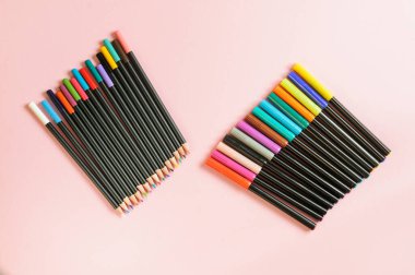 Kalemlerin üst görünümü ve farklı renkteki işaretler. Kopya alanı ile pembe arkaplan