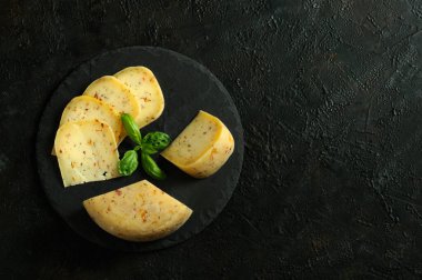 Siyah tahtada dilimlenmiş yuvarlak peynir. Yukarıdan bak. Kopyalama alanı ile seçmeli odak