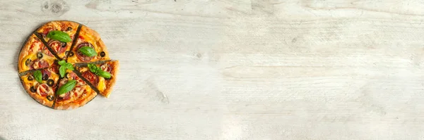 Gri ahşap arka planda salamlı, domatesli ve kırmızı biberli pizza. Kopyalama alanı olan üst görünüm. Pankart