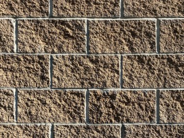 Yakından bakınca beton blok duvar parlak güneş ışığı ve derin gölgeler ile