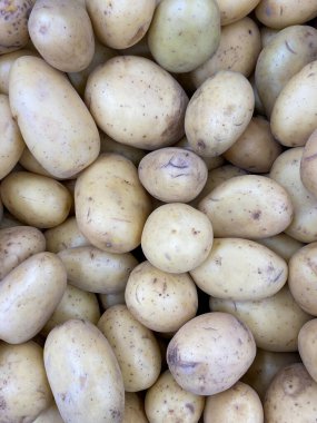 Doğal güneş ışığı altında organik çiftçilerin marketlerinde yeni patatesler yığılıyor.