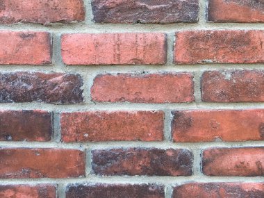 Kırmızılı ve çok renkli taşlı, gri, yıpranmış ön cepheli eski tuğla duvarın güzel yakın görüntüsü