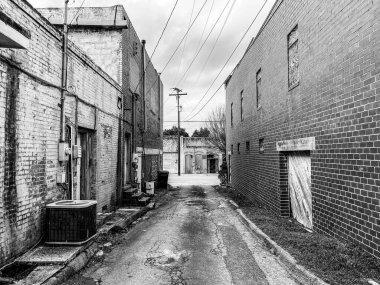 Terk edilmiş kırsal kesimin arka sokaklarında karanlık, kasvetli bir umutsuzluk içinde mimarlık sahnesi olarak siyah ve beyaz.