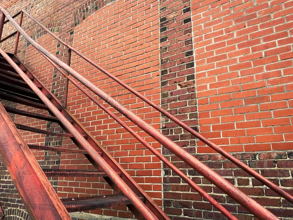 back alley steps stairs rusting against a retro weathered aging brick warehouse building