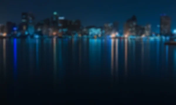 Blue city view from seaside  at night - blurred photo