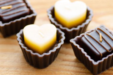 Ahşap arka plan üzerinde kahverengi mumları grubudur. Kalp şeklinde mum