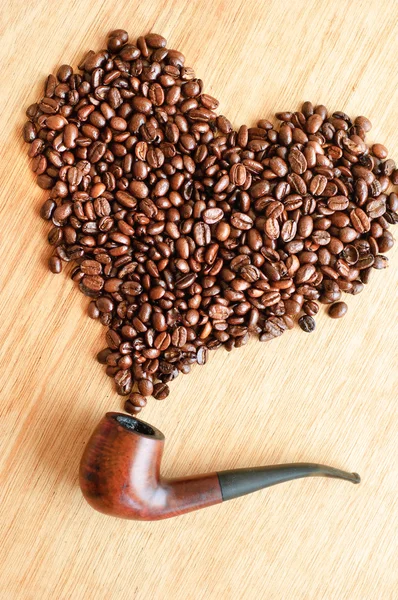 Coffee beans and smoking pipe — Stock Photo, Image