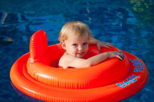 Baby swimming in the orange float — Stock Photo, Image