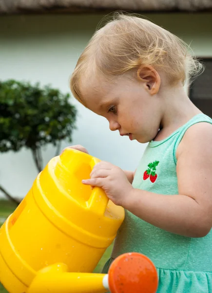 Baby girl with the watering can — Stock Photo, Image