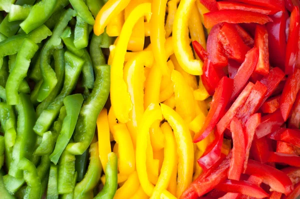 Sliced colourful paprika peppers background — Stock Photo, Image