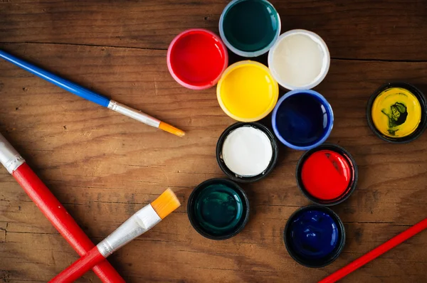 Watercolors and brushes on wooden background — Stock Photo, Image