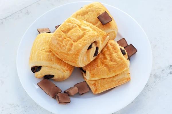 Chocolate croissants on white plate — Stock Photo, Image