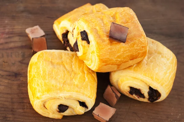 Chocolate croissants on wooden background — Stock Photo, Image