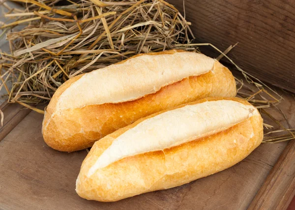 Baguettes frescos en una mesa de madera — Foto de Stock