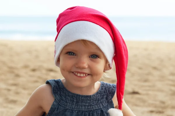 Cute girl in Santa hat having fun at the tropicals — Stock Photo, Image